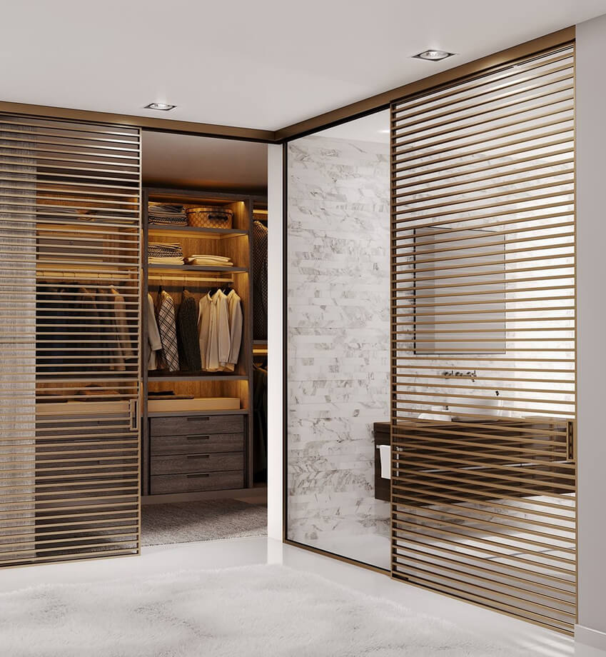 Moderner begehbarer Kleiderschrank mit Holzregalen, mehreren Hemden und Schubladen, daneben ein Bad mit Marmorwand und Waschtisch hinter Lamellentüren. Moderner begehbarer Kleiderschrank mit Holzregalen, mehreren Hemden und Schubladen, daneben ein Bad mit Marmorwand und Waschtisch hinter Lamellentüren.